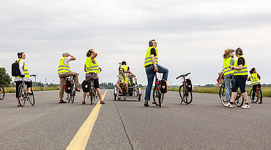 Einige Menschen stehen mit ihren Fahrrädern auf der Landebahn des ehemaligen Flughafens Tegel
